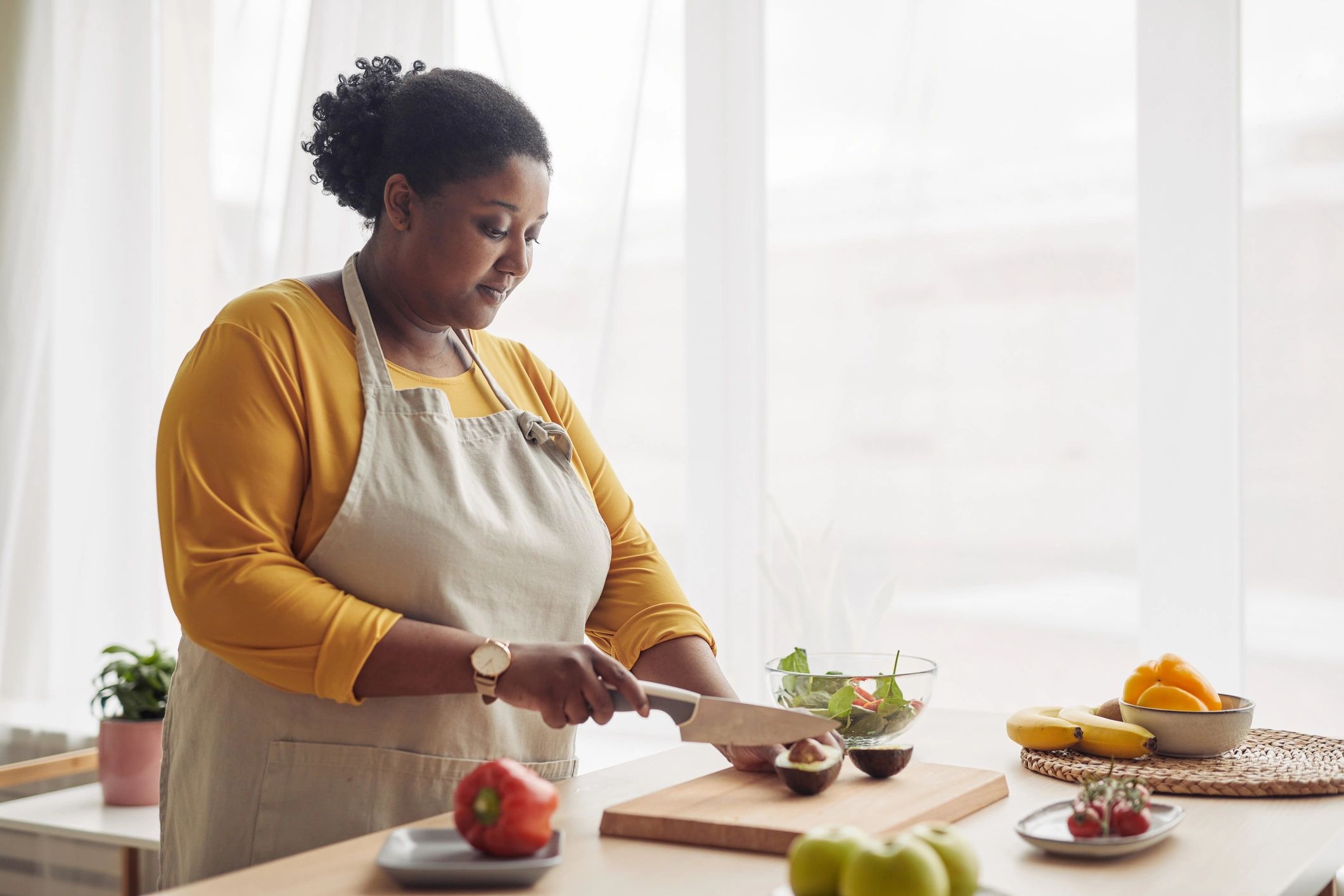 Woman cooking at home in a sunlit kitchen